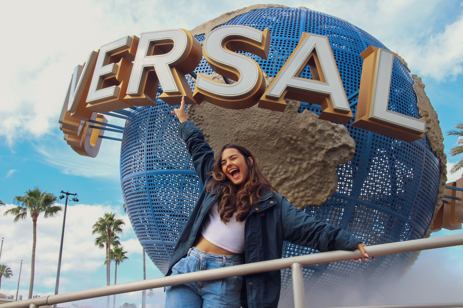 Sara Reis em viagem diante do globo da Universal